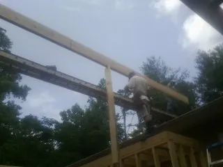 Carpenter setting a ridge beam over a new addition frame — Ice Dam Removal by Roofing Brothers in East Fultonham