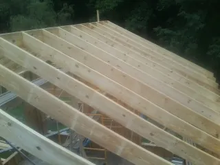 New roof rafters set over an addition before sheathing in East Fultonham