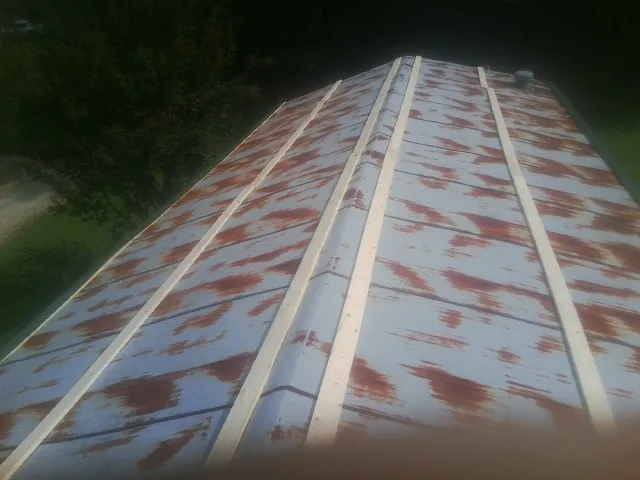 Rusted metal roof panels with new wood purlins before replacement — Storm Damage Roof Repair in East Fultonham by Roofing Brothers