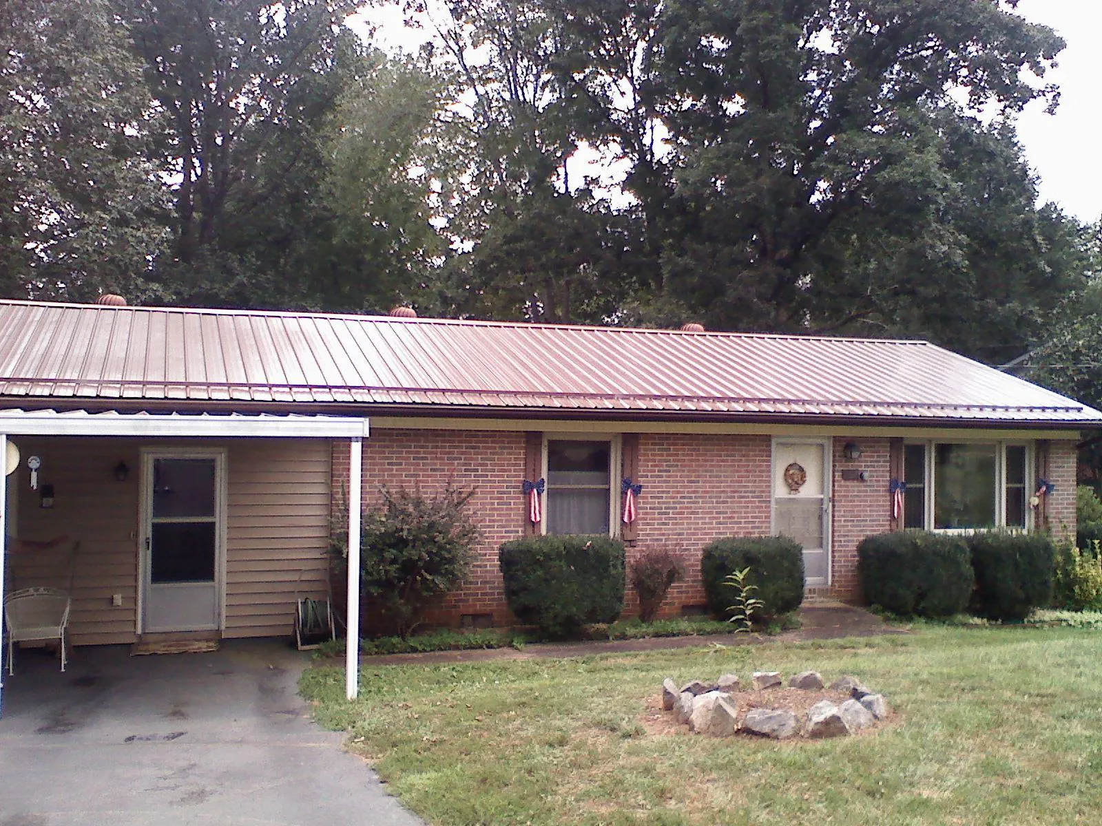 Bronze metal roof and carport on a brick ranch home — Roof Repair work by our crew in East Fultonham